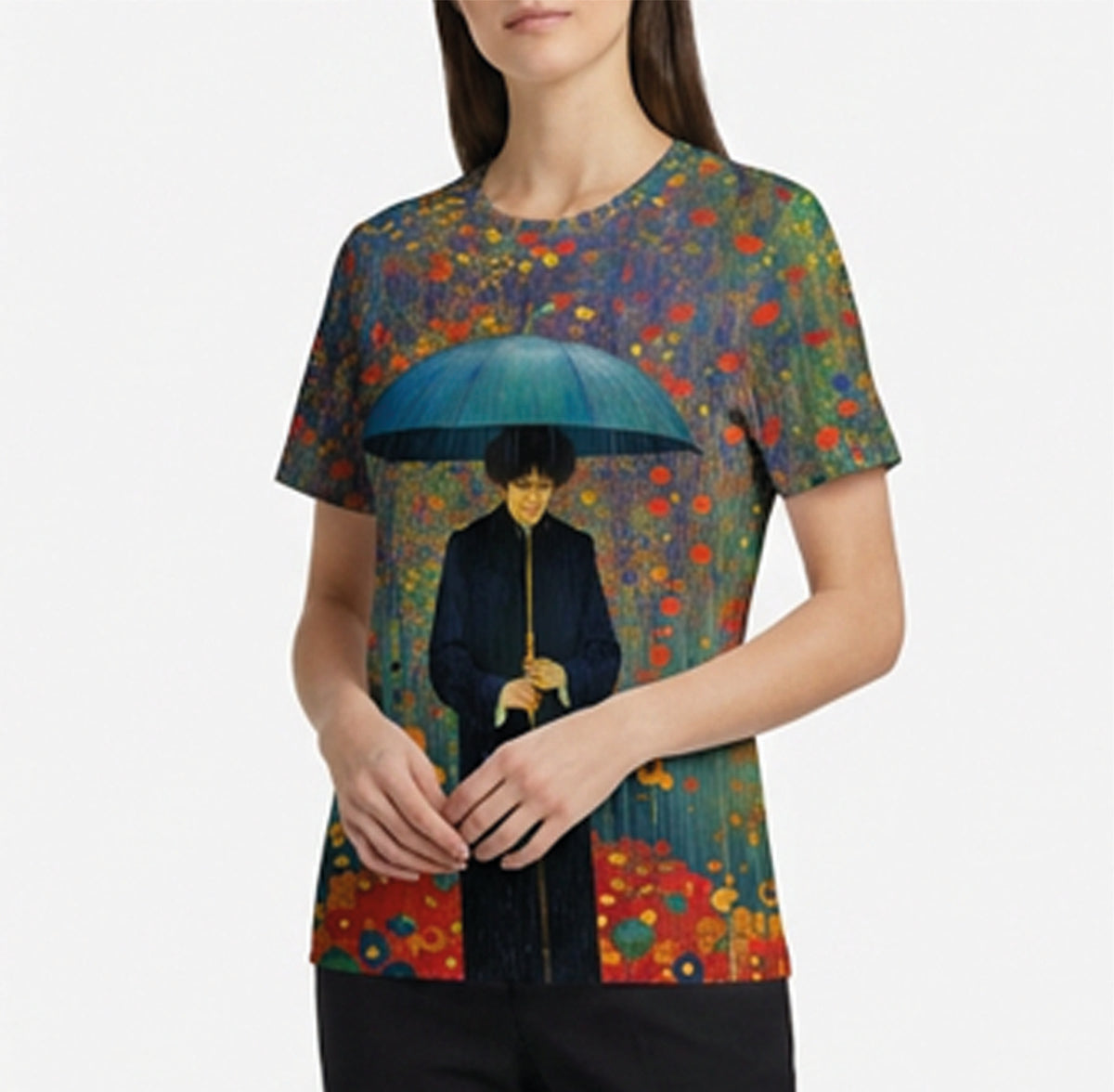 A woman wearing a short-sleeve crewneck t-shirt featuring a colorful, impressionistic art print of a figure holding a blue umbrella, set against a plain light gray background.