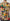 A person shown from the back wearing a short-sleeve t-shirt with a vibrant abstract geometric print inspired by Piet Mondrian, featuring red, yellow, green, and blue shapes on a beige background.